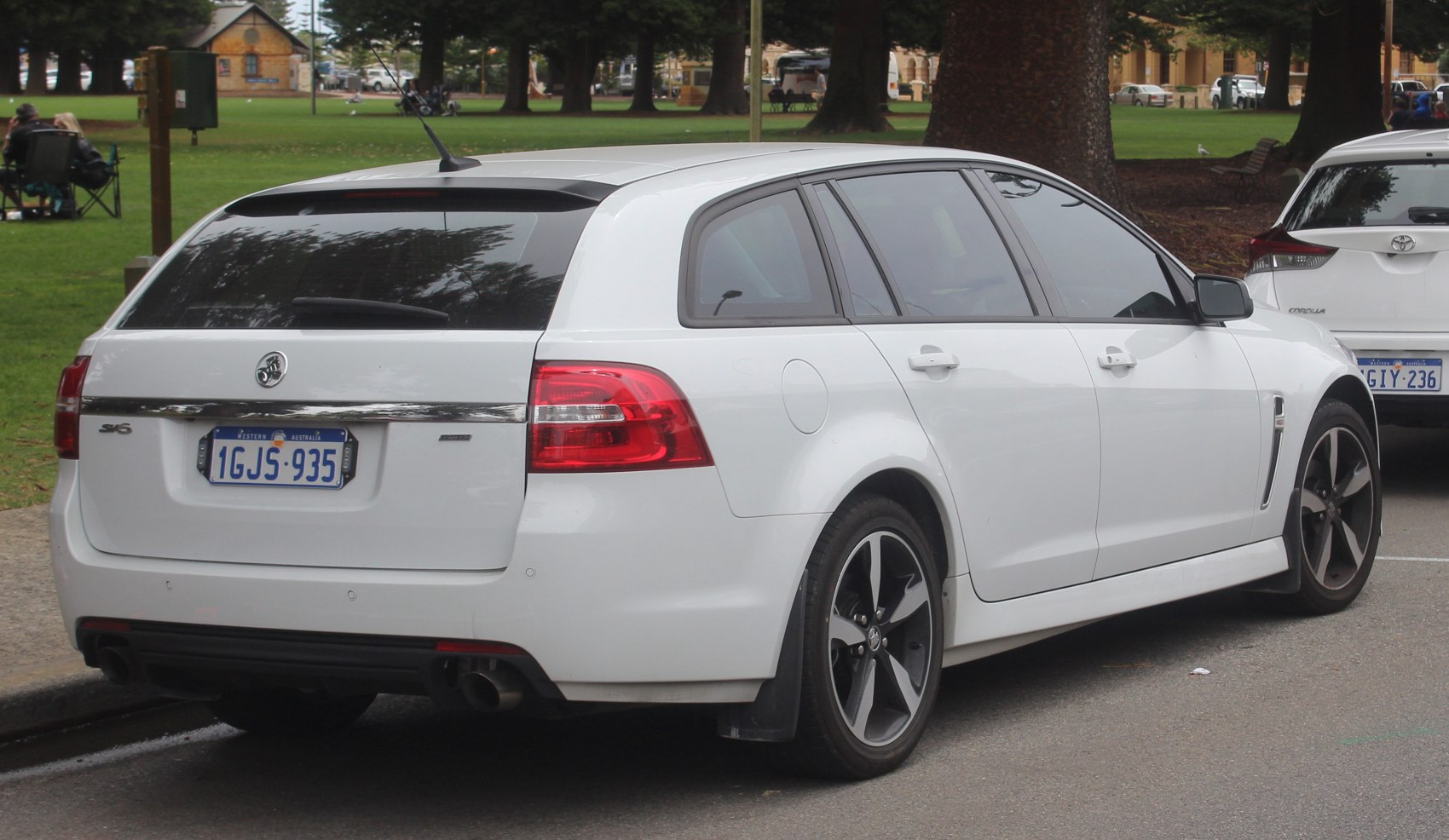Rear and side view of white station wagon with sporty wheels