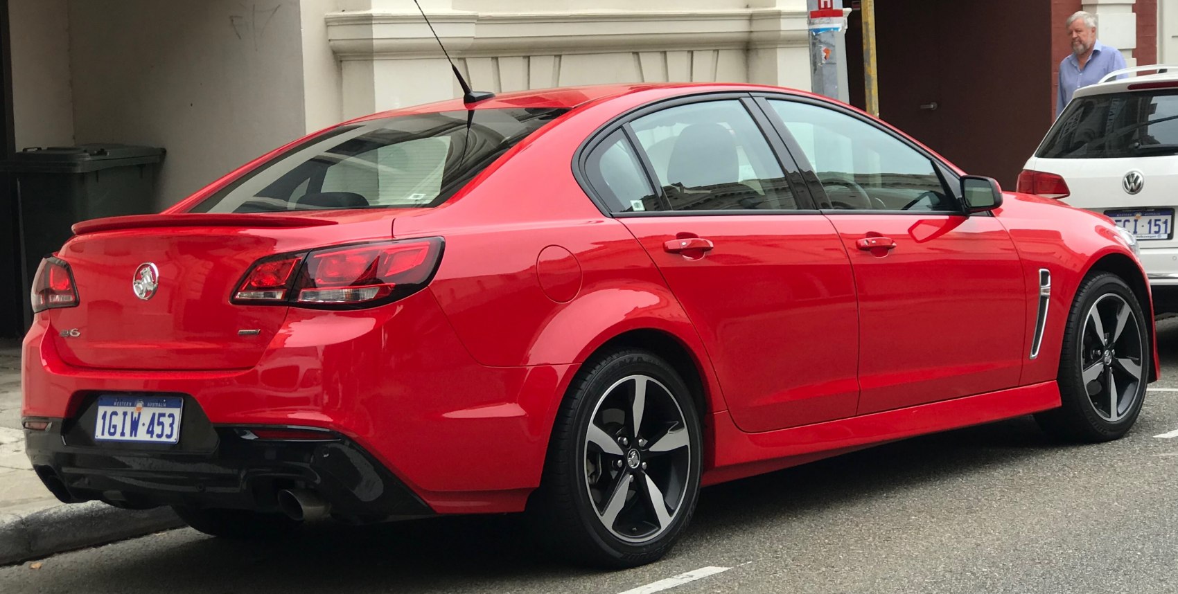 Red sedan with dual exhaust, rear spoiler, and sleek taillights.