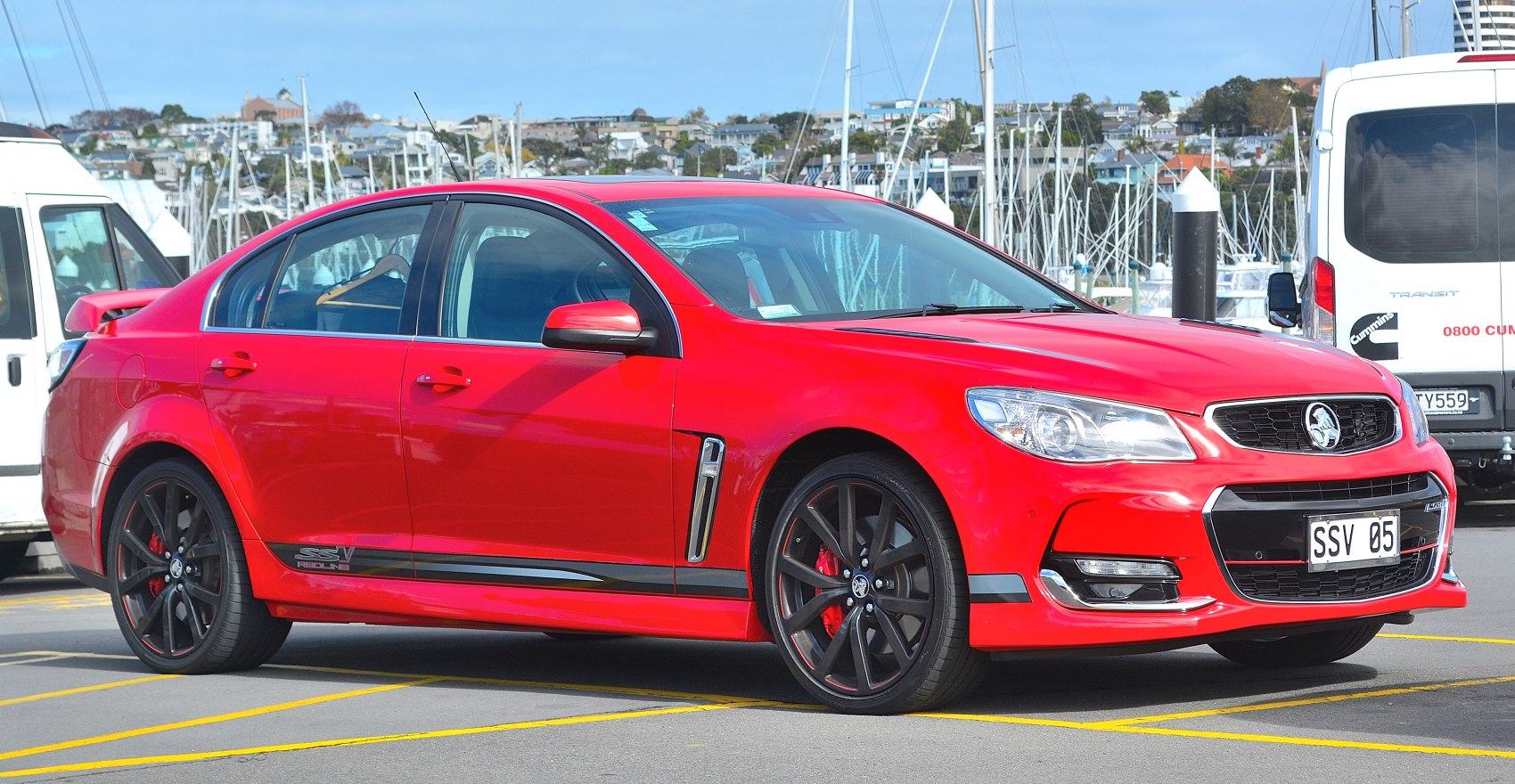 Red sports sedan with black wheels and rear spoiler