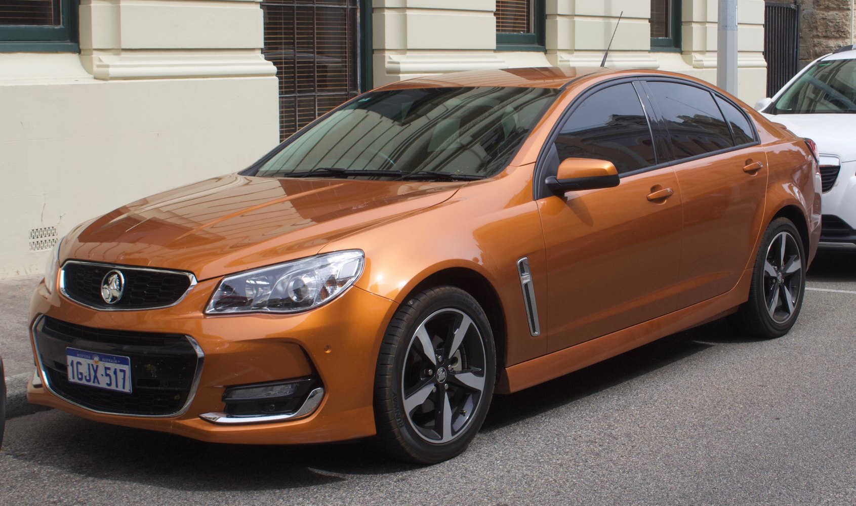 Front-side view of a modern sedan with alloy wheels and prominent grille.