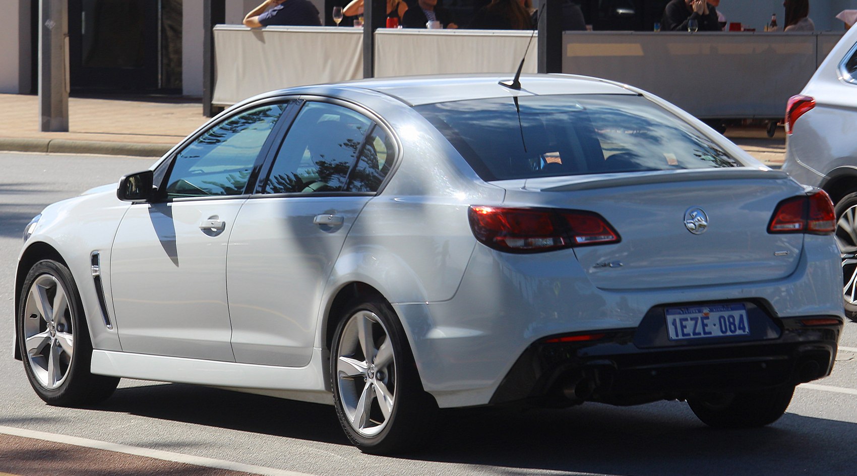 Sedan rear side with alloy wheels, spoiler, and taillights