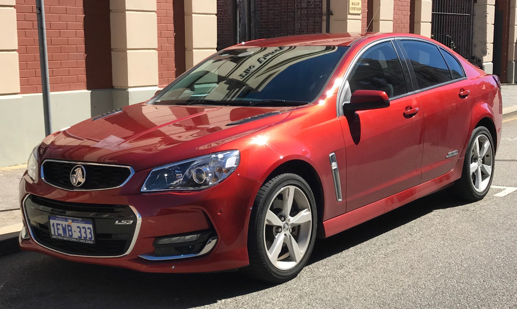Red mid-size sedan with sporty front and alloy wheels