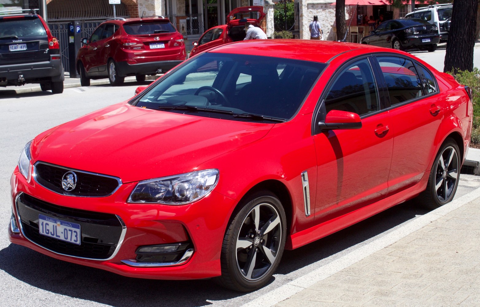 Red sedan front side with alloy wheels and modern design