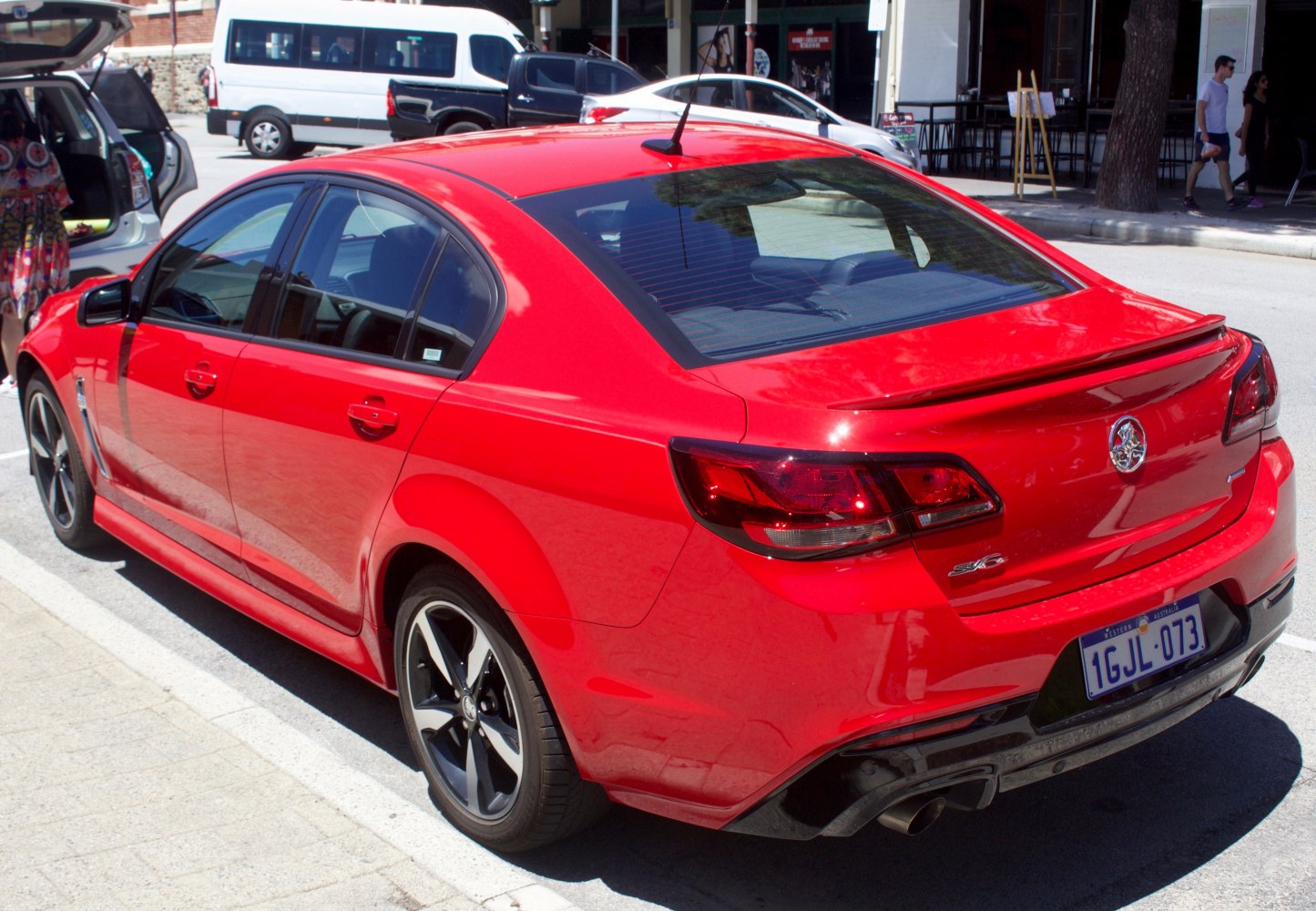 Sporty rear sedan with taillights, spoiler, and alloy wheels