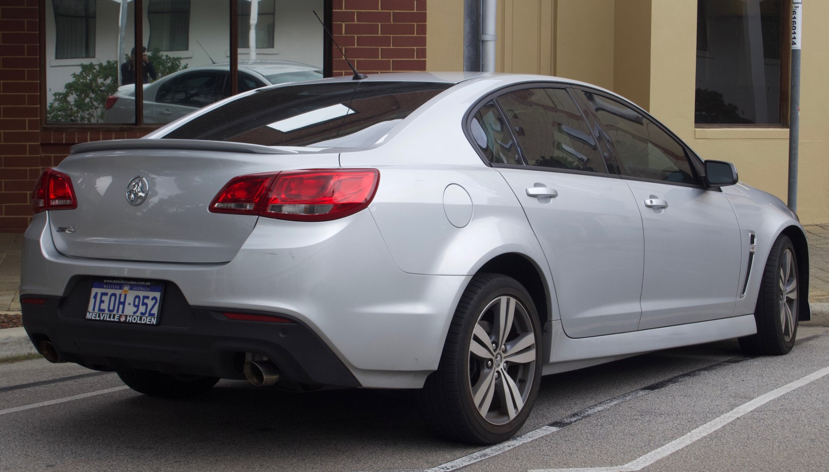 Rear view of a silver four-door sedan with dual exhaust and alloy wheels.