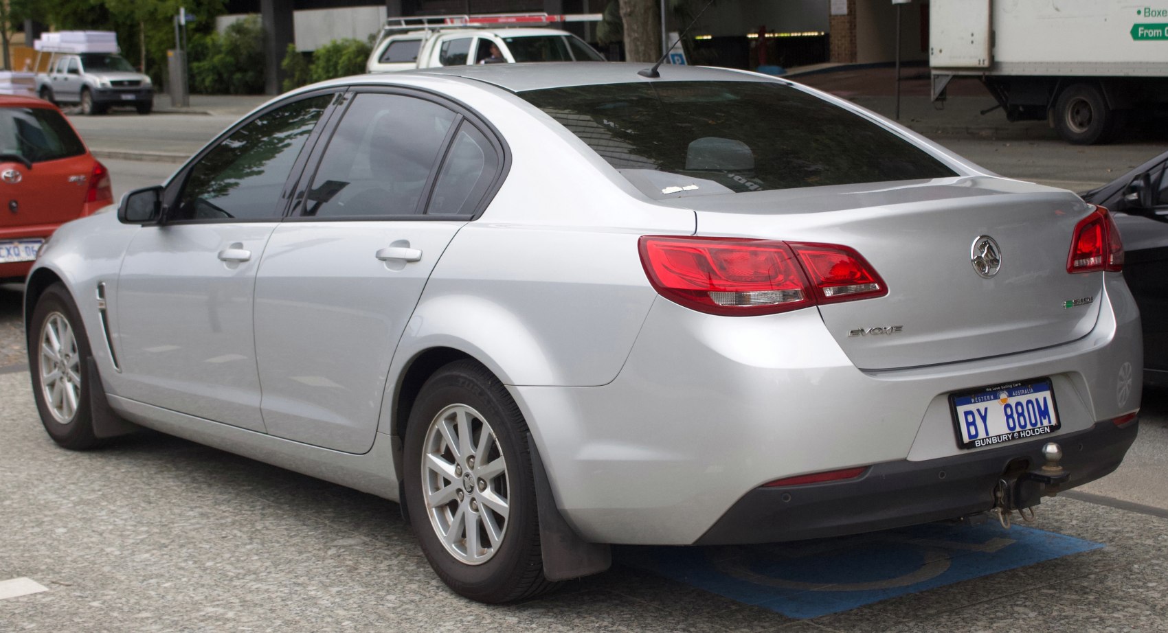 Rear side view of silver sedan with distinct taillights and alloy wheels