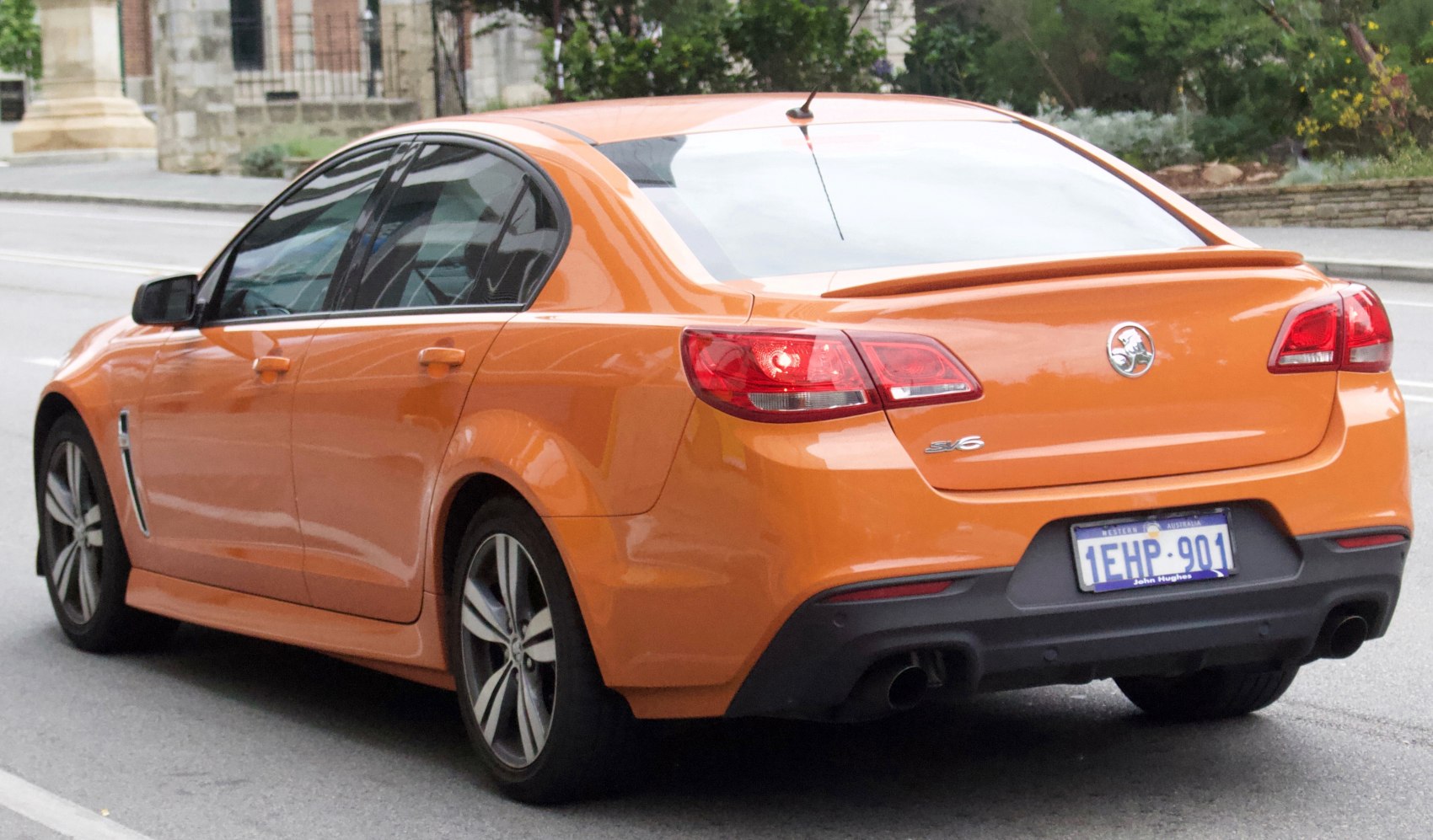 Rear view of orange sedan with distinctive taillights and rear spoiler