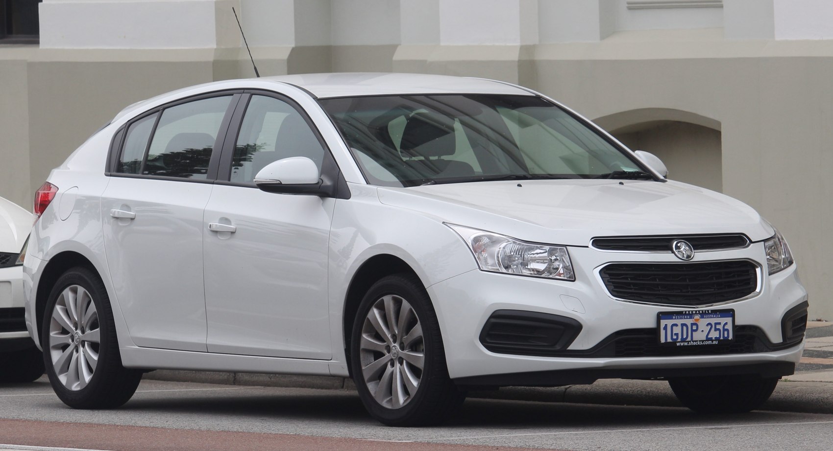 White 2015 hatchback with distinctive headlights and front grille.