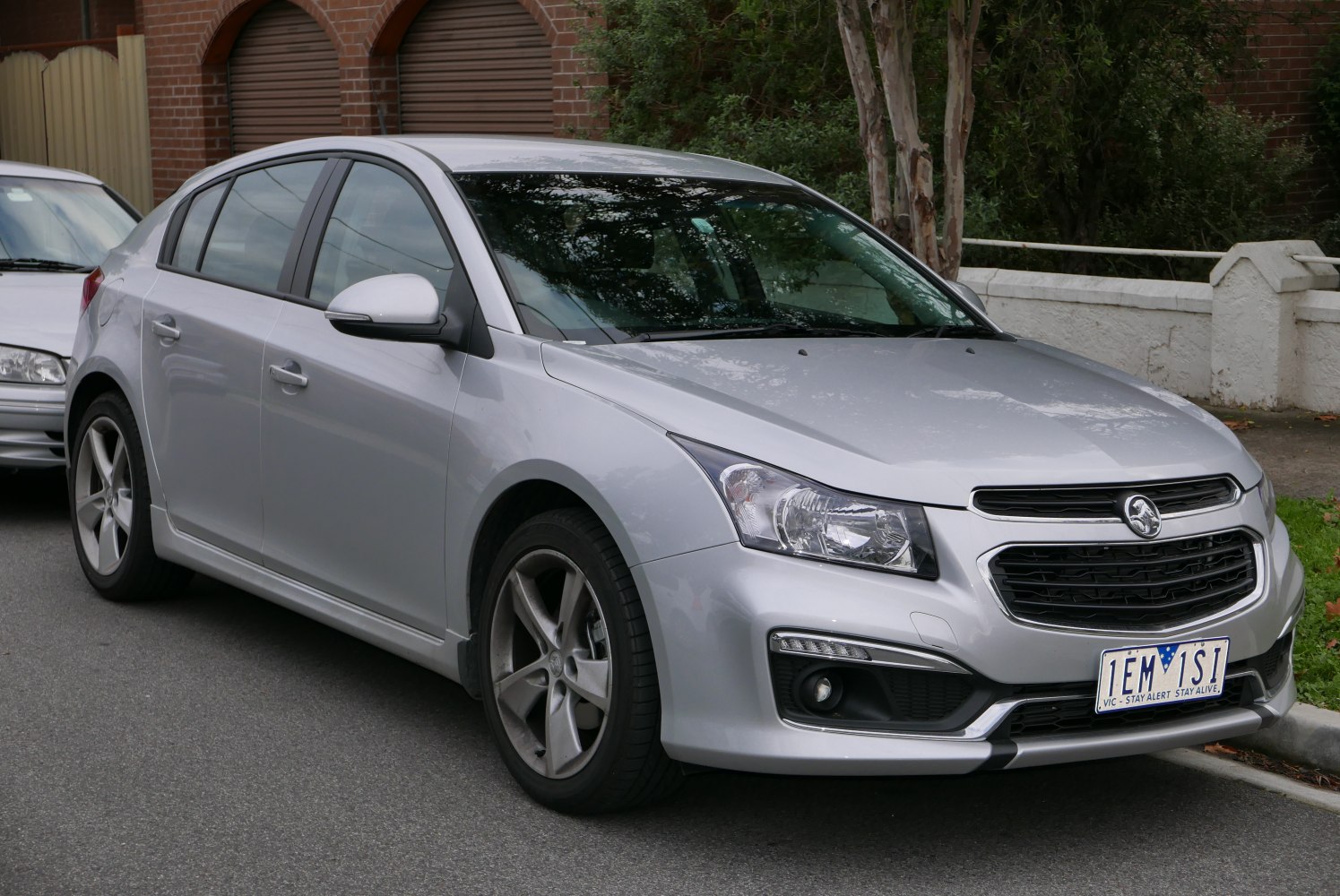 Silver hatchback with clear headlights and bold grille