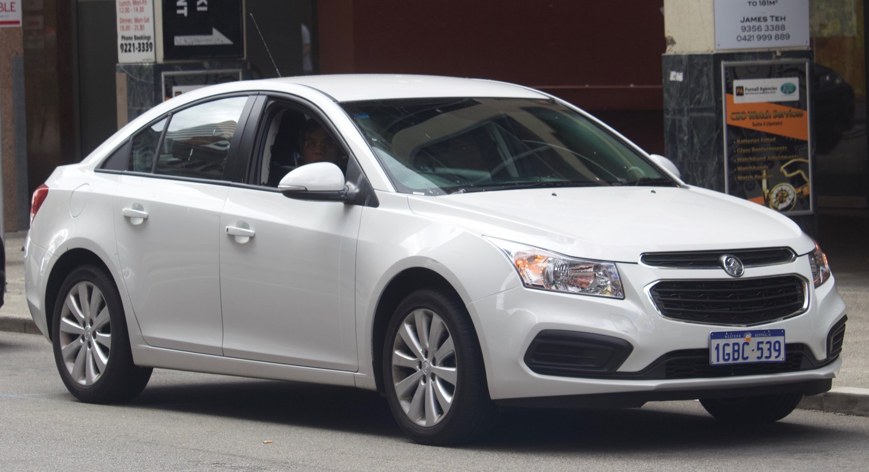 White sedan showing front grille and side profile