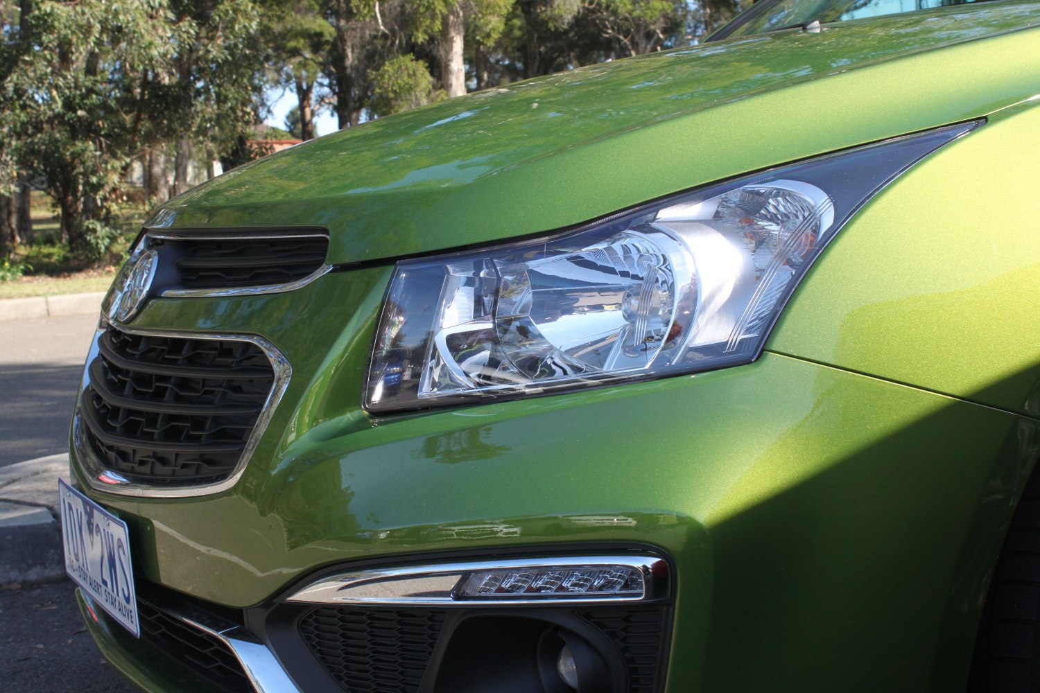 Front grille and headlight of green sedan