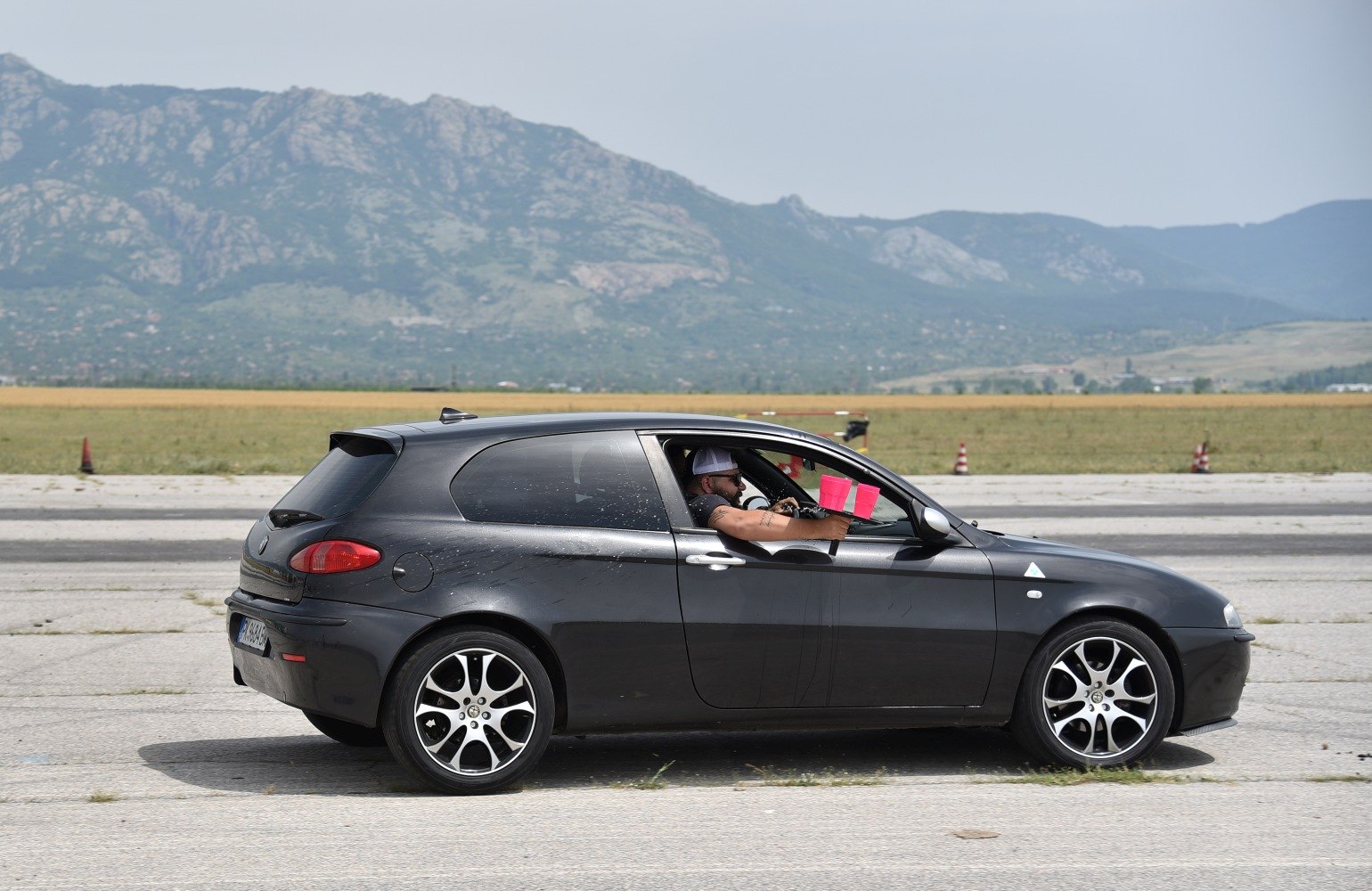 Side view of 3-door hatchback with distinctive alloy wheels and tinted rear windows
