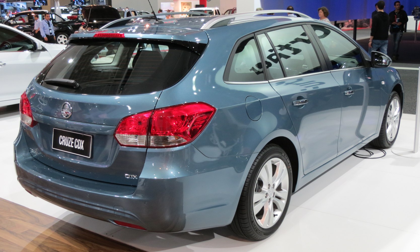 Rear and side view of a blue wagon with roof rails and distinct taillights