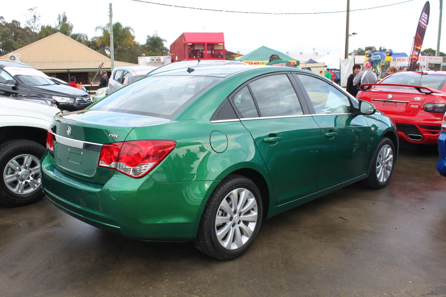 Green mid-size sedan rear side view with distinct taillights and alloy wheels.
