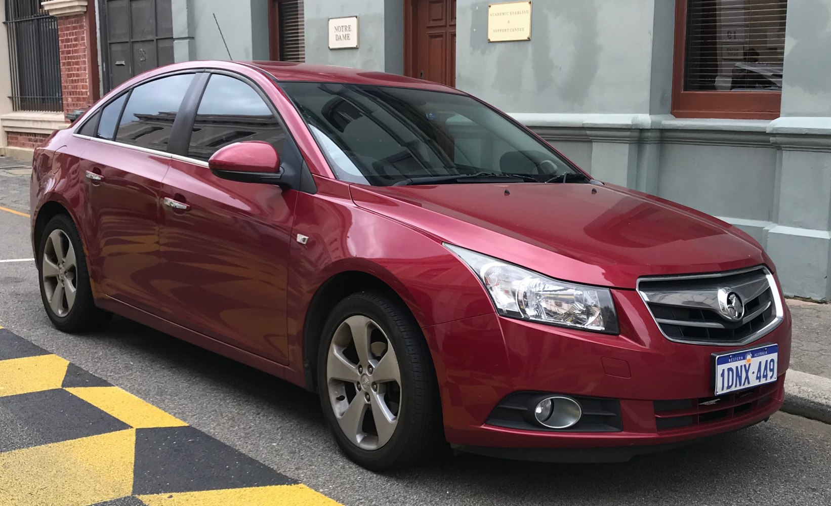 Red sedan with front-side view and alloy wheels