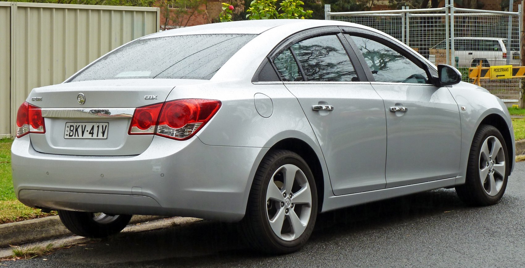 Silver sedan rear side with distinct tail lights and alloy wheels