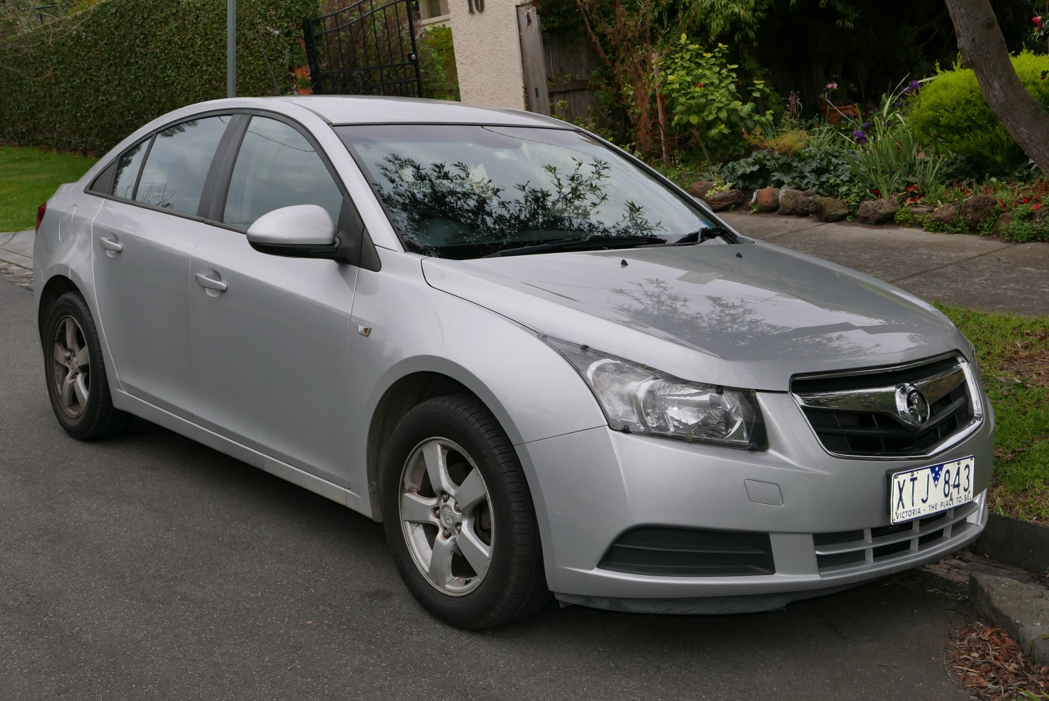 Front side view of a silver sedan with distinct headlights and four doors.