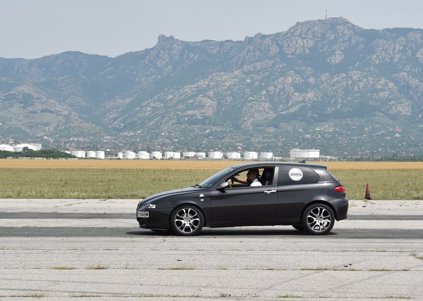 Side profile of a 3-door hatchback with alloy wheels.