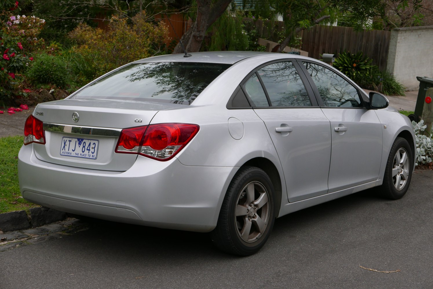 Silver four-door sedan rear view with distinct red tail lights and sleek body contours