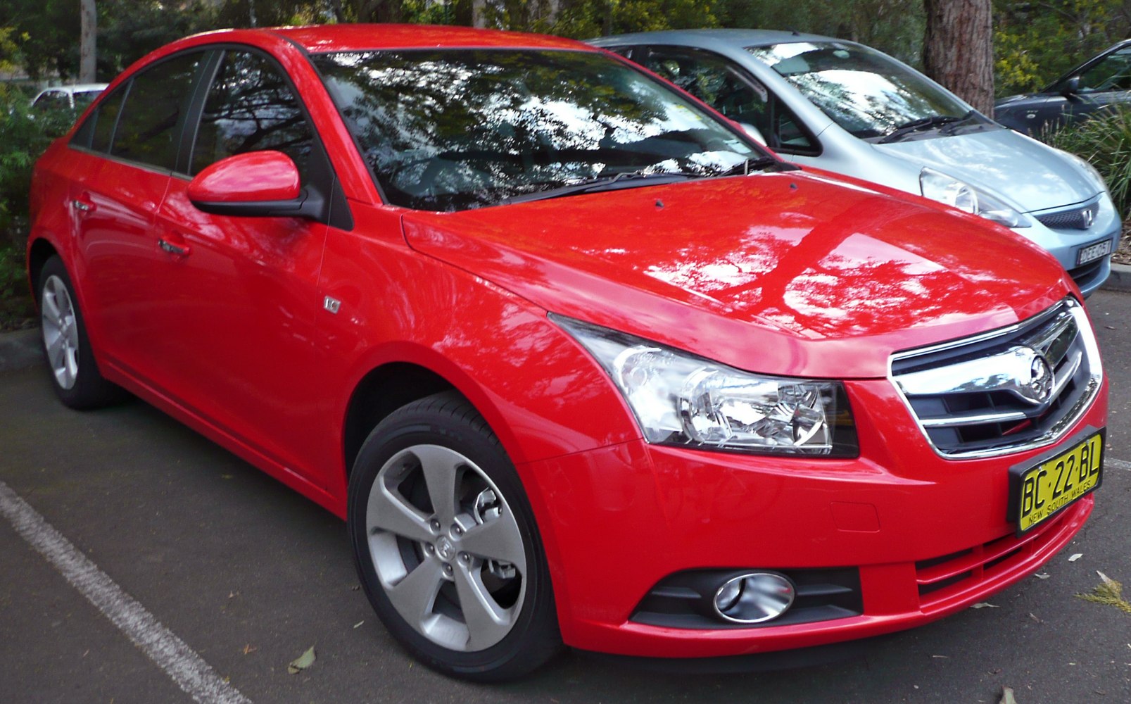 Front view of a sedan with prominent grille, headlights, and alloy wheels.