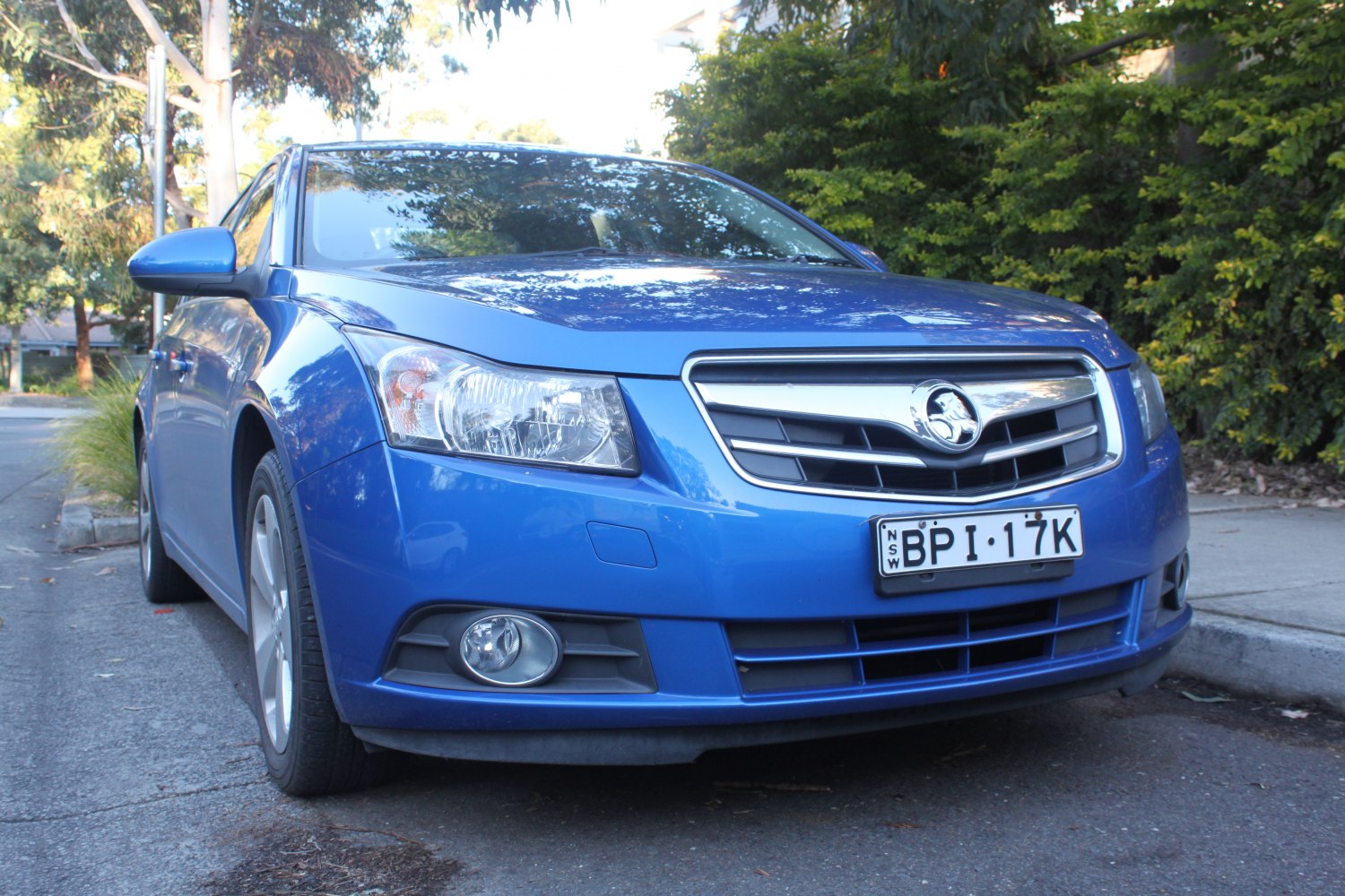 Blue sedan front with chrome grille and fog lights