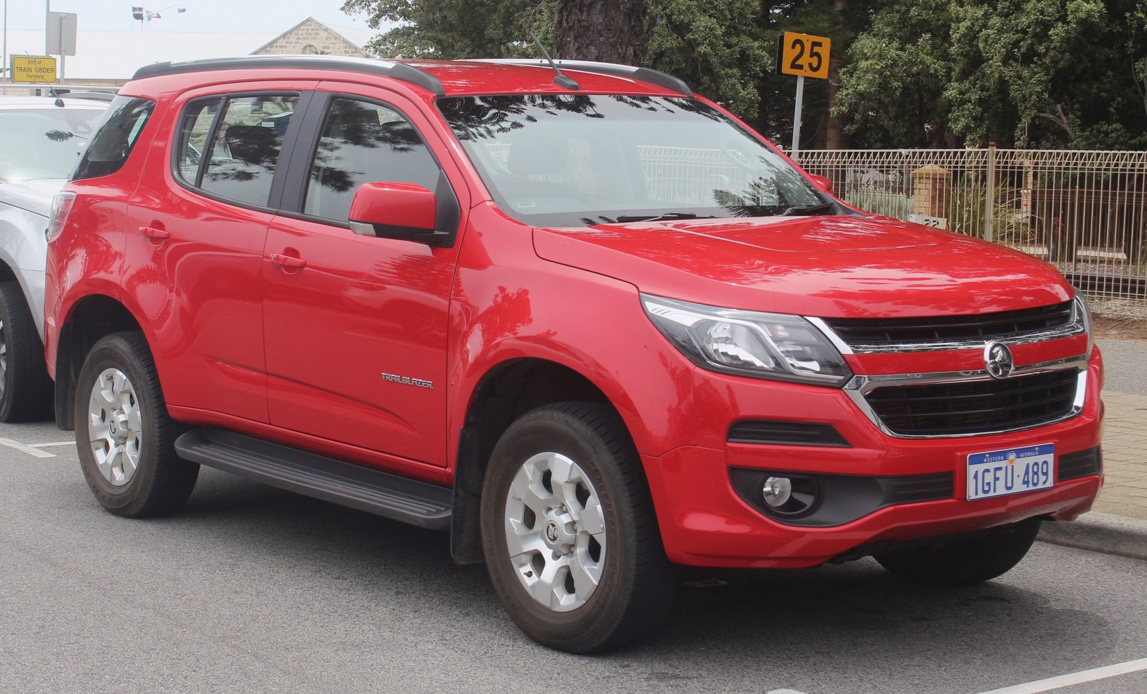 Red SUV with chrome grille and side running boards