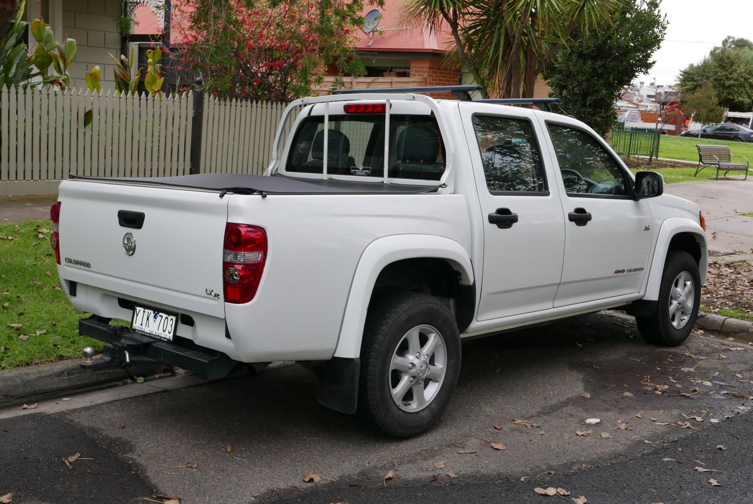 Rear and side view of double cab pickup with tonneau cover and tow hitch