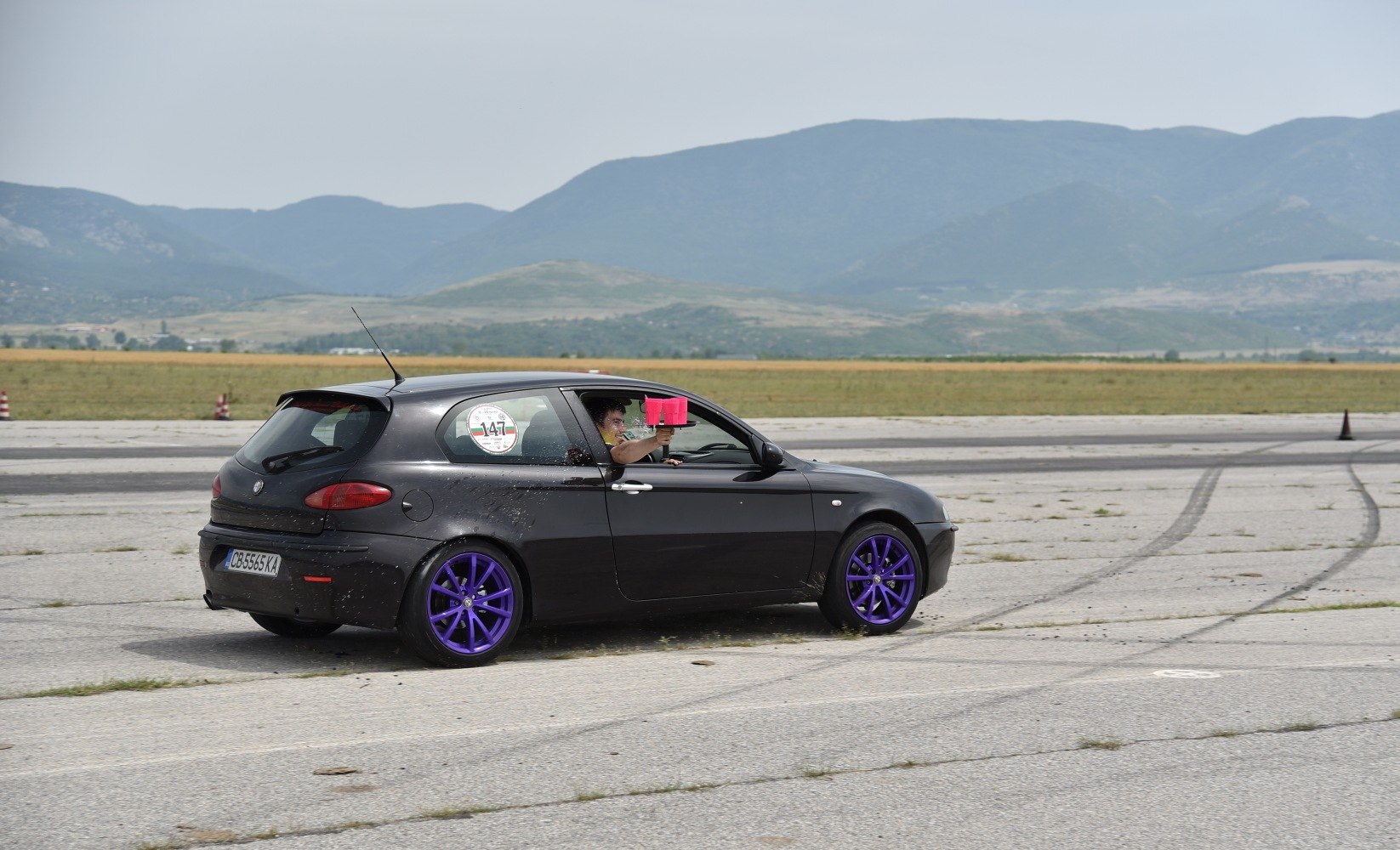 Black 3-door hatchback with vivid purple alloy wheels
