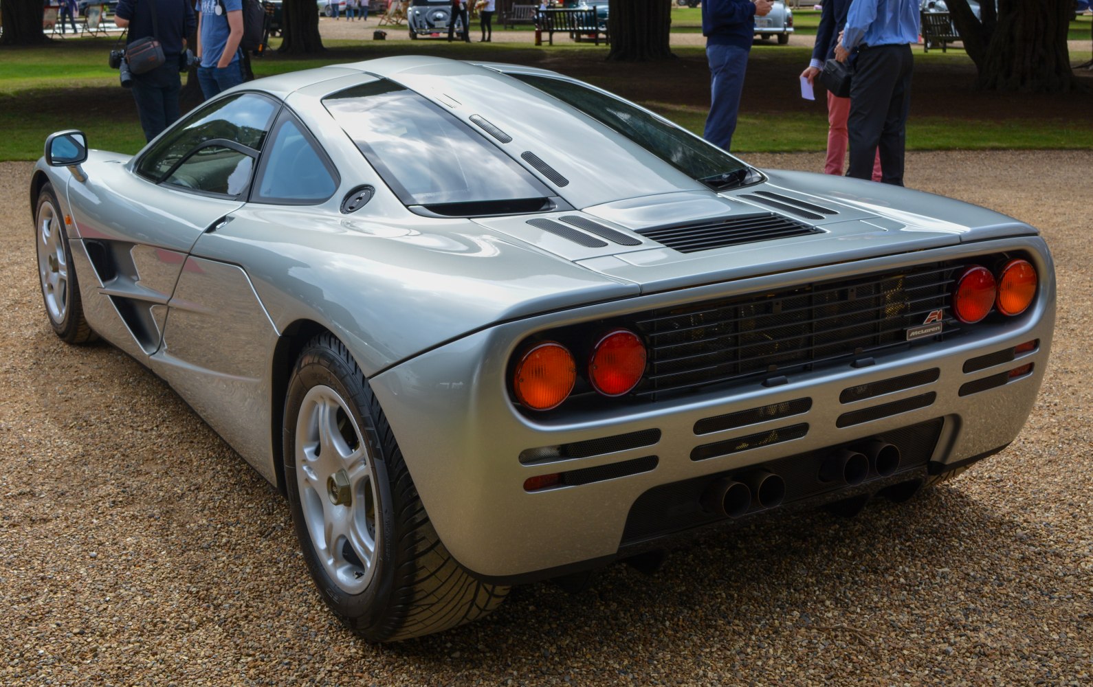 Rear view of a mid-engine sports car with quad exhausts and round taillights