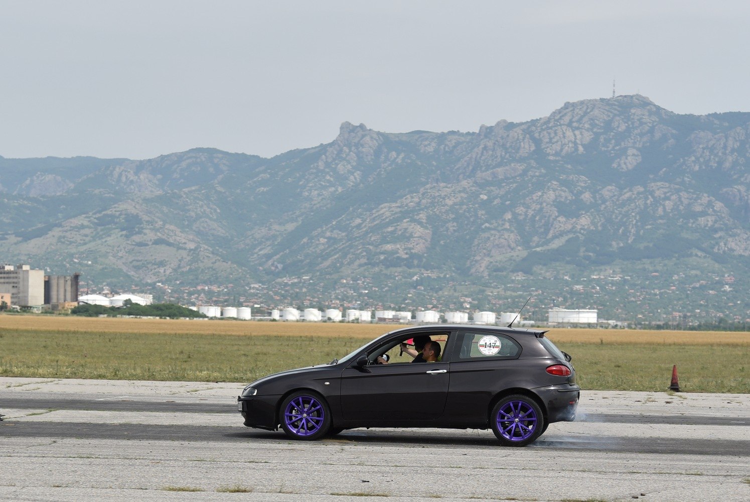 Side view of black 3-door hatchback with purple wheels
