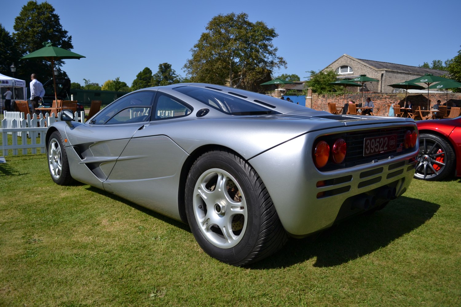 Silver supercar rear side view with distinctive taillights and aerodynamic shape