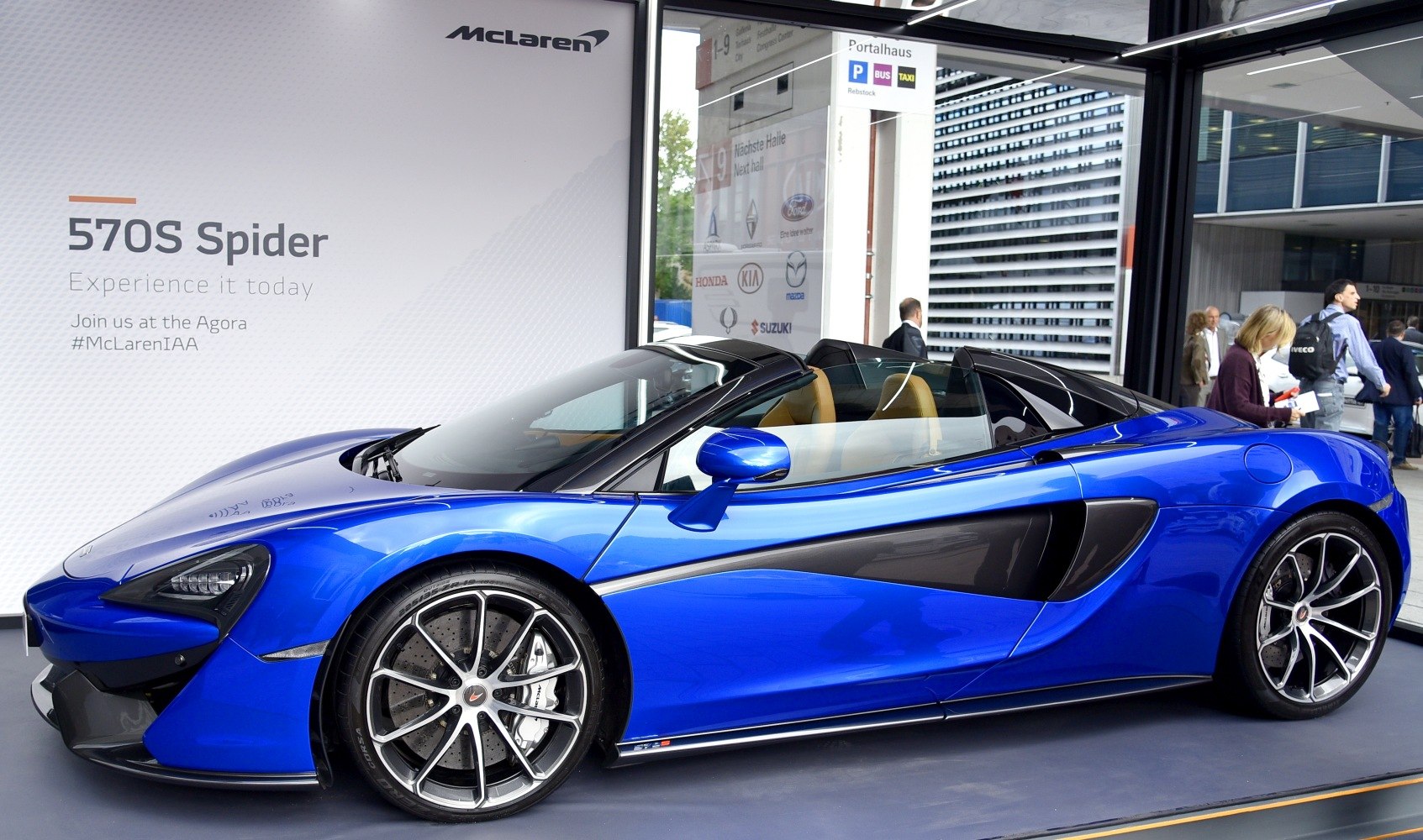 Side profile of a blue convertible sports car with aerodynamic features.