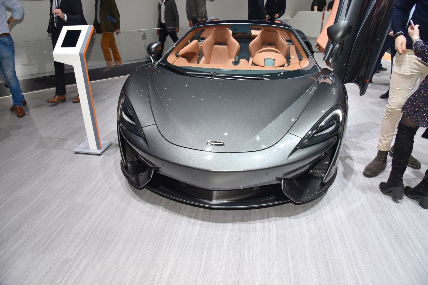 Aggressive aerodynamic front with open scissor door and tan leather seats