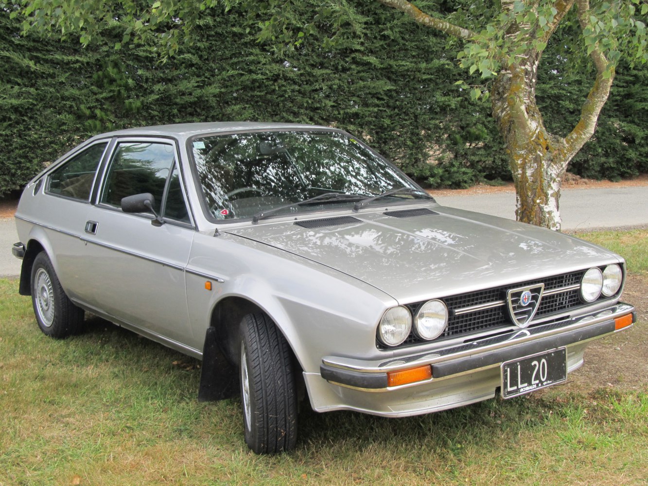 Silver classic vintage coupe with dual round headlights and sporty front design
