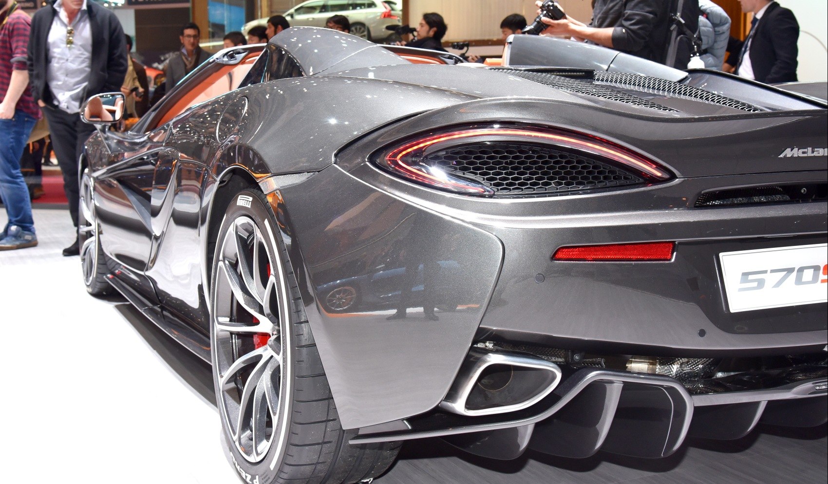 Rear view of a sports car with distinctive tail lights, sporty wheels, and exhaust detail