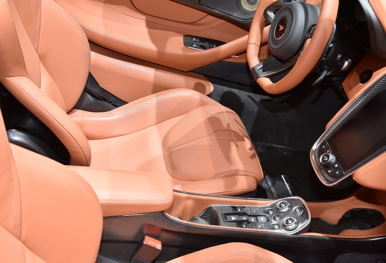 Tan leather seats and carbon fiber center console in luxury sports car interior