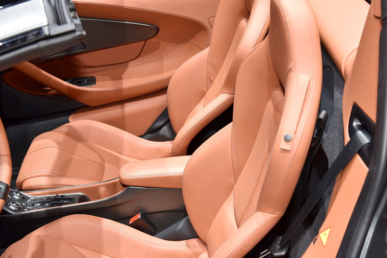 Tan leather luxury seats and carbon fiber trim in sports car interior