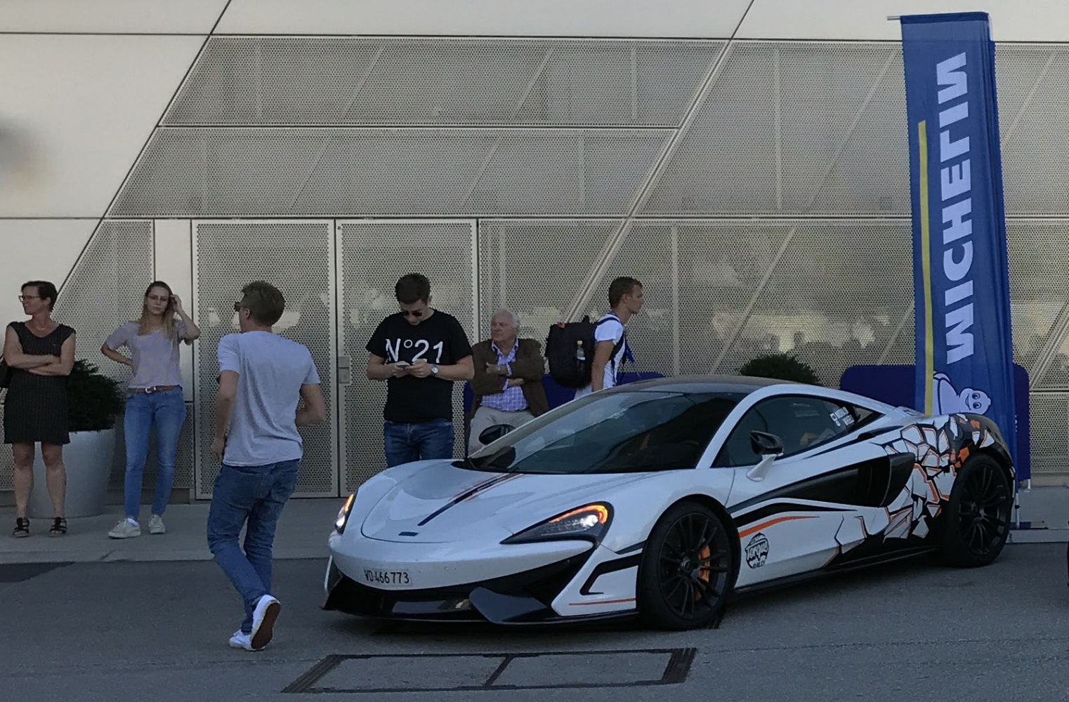 Sleek white sports car with custom side graphic and aerodynamic front splitter