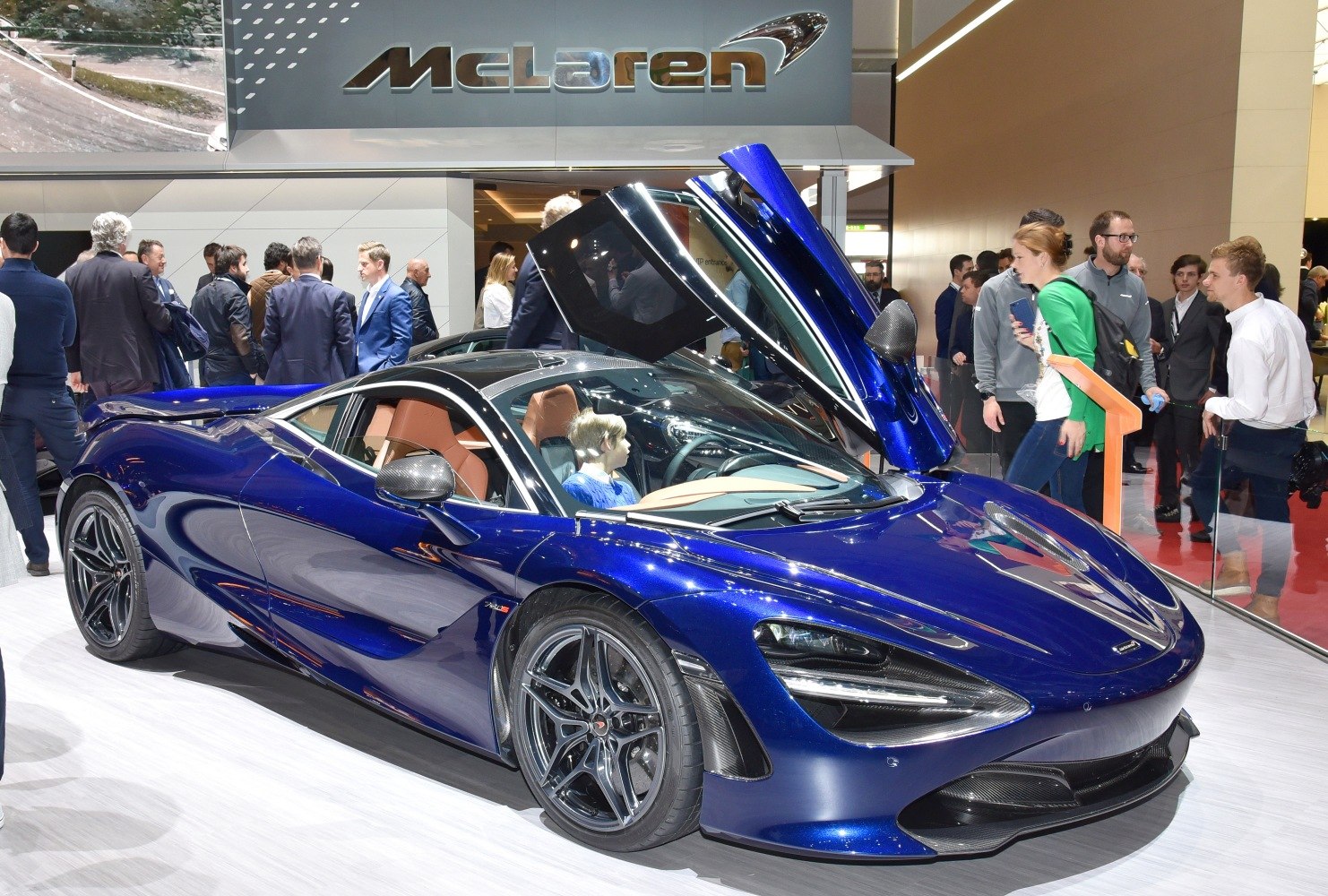 Blue sports car with butterfly doors open and aerodynamic design