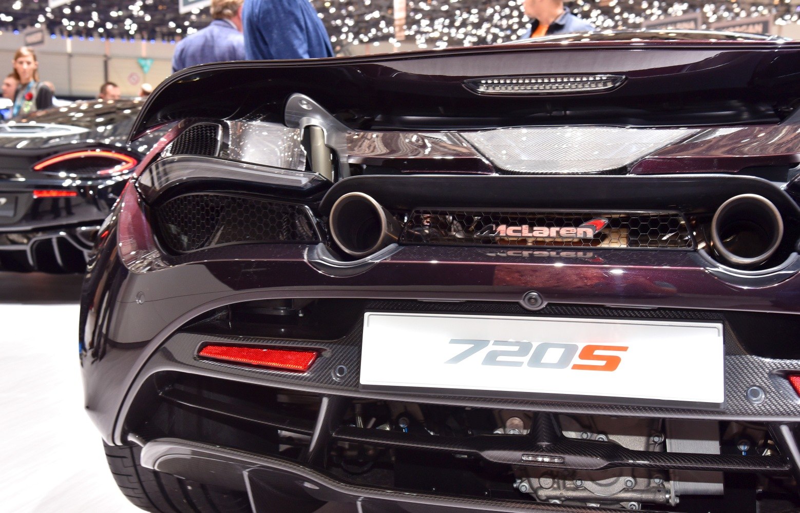 Dual exhaust pipes and tail light on rear of a high-performance supercar.