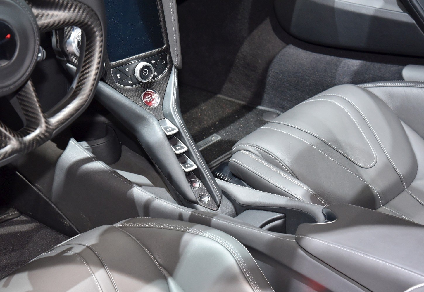 Center console with carbon fiber, start button, and leather seats