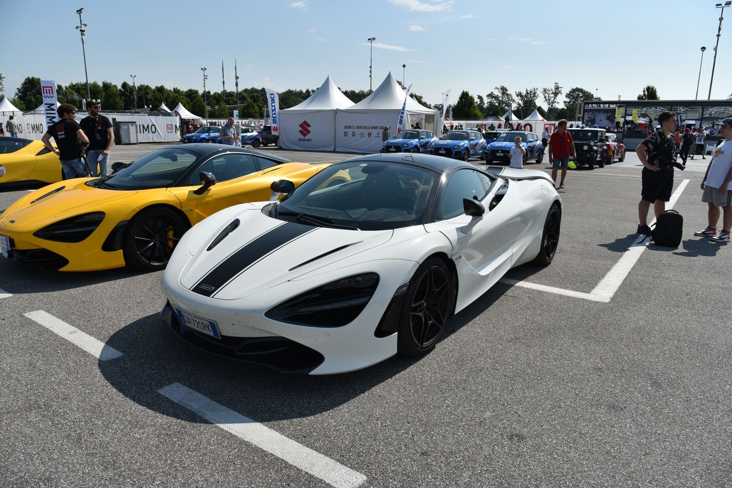 White supercar with black racing stripes and sleek aerodynamic design