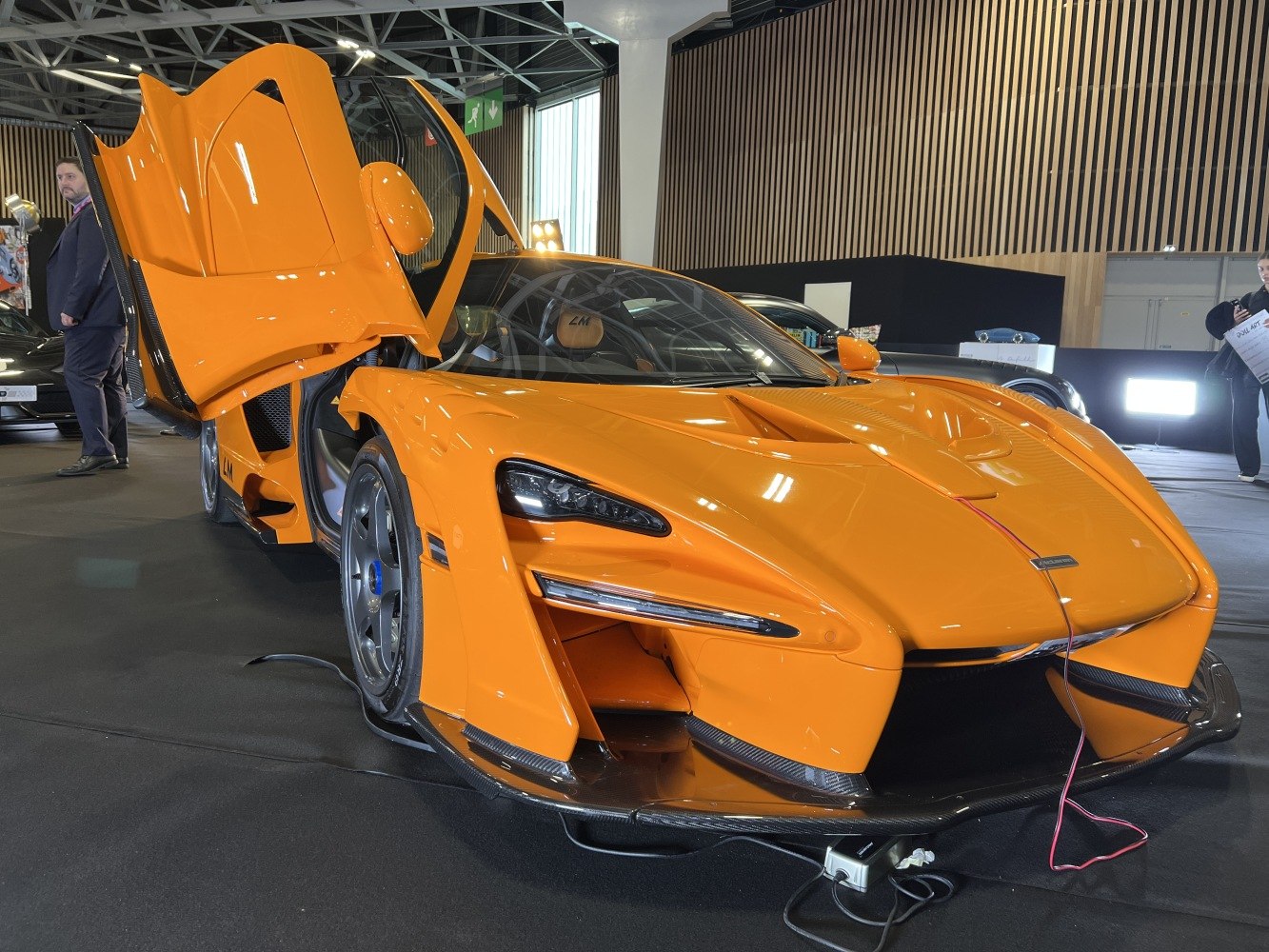 Orange sports car with butterfly doors and aero body features