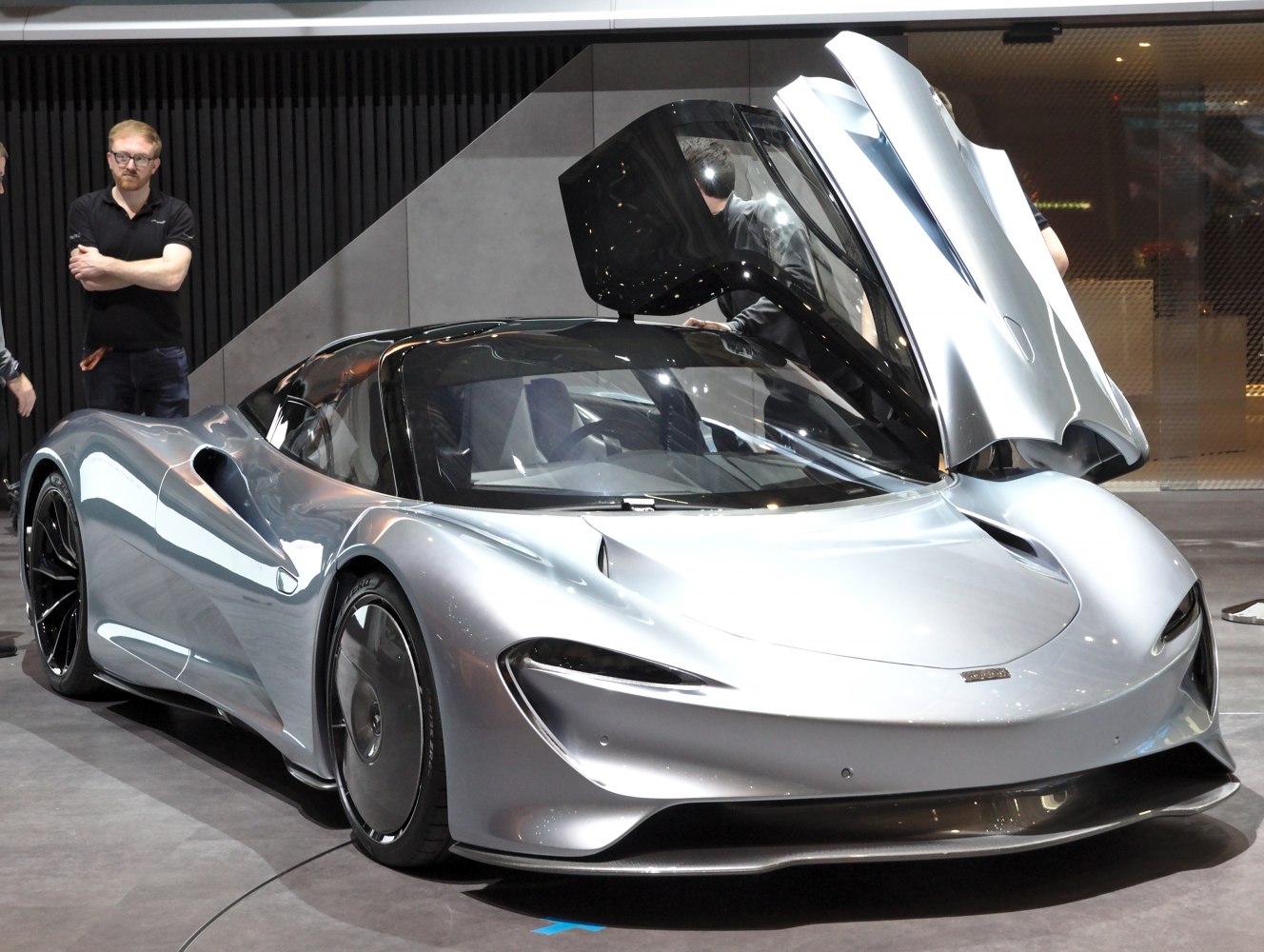 Sleek silver sports car with gullwing door and aerodynamic styling