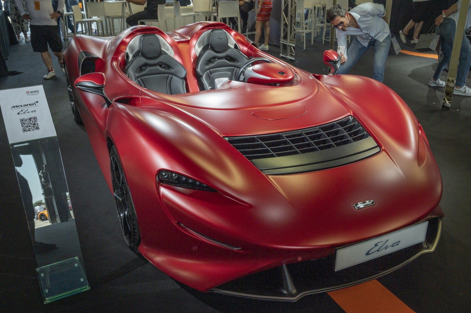 Sleek red supercar with open cockpit and aerodynamic front design