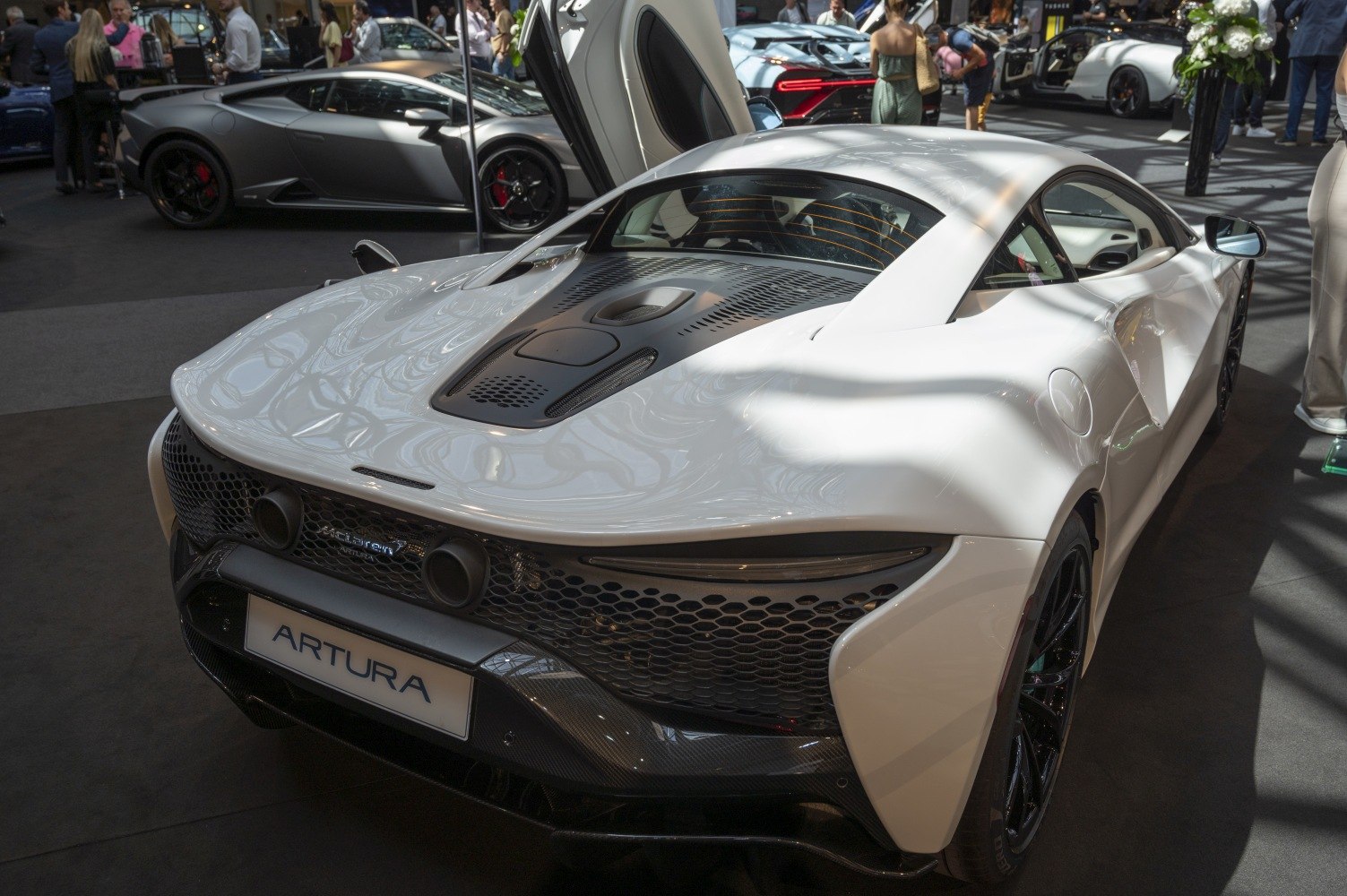 Rear view of sports car highlighting dual exhaust, aerodynamic rear design, and black wheels.