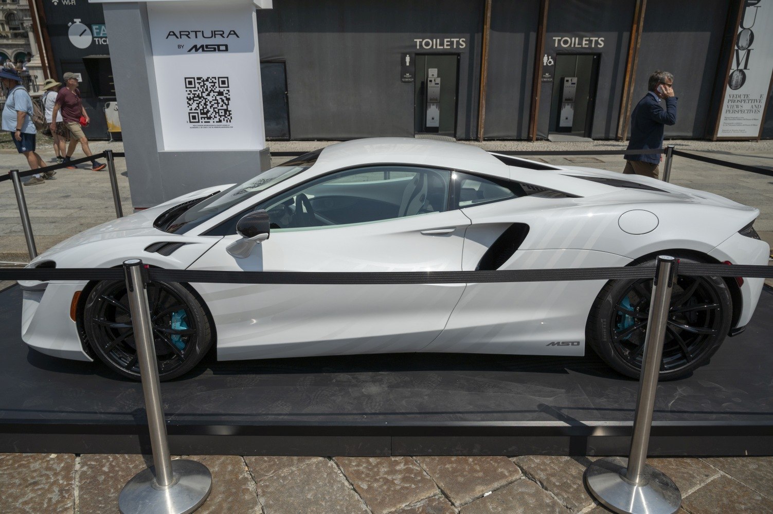 White mid-engine sports coupe side view with black rims