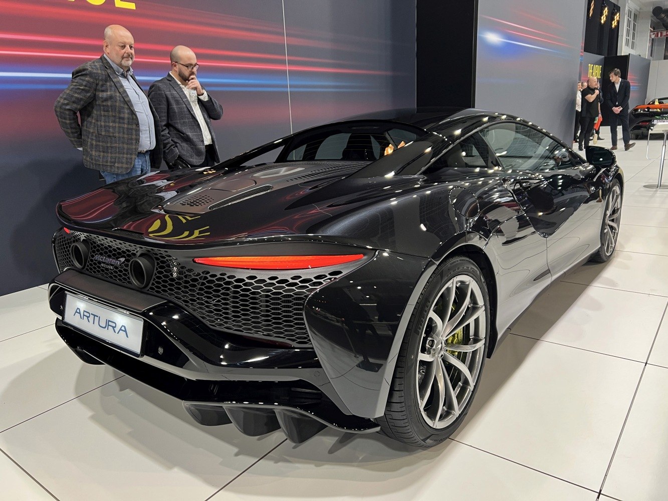 Sleek black rear view with dual exhausts and honeycomb grille