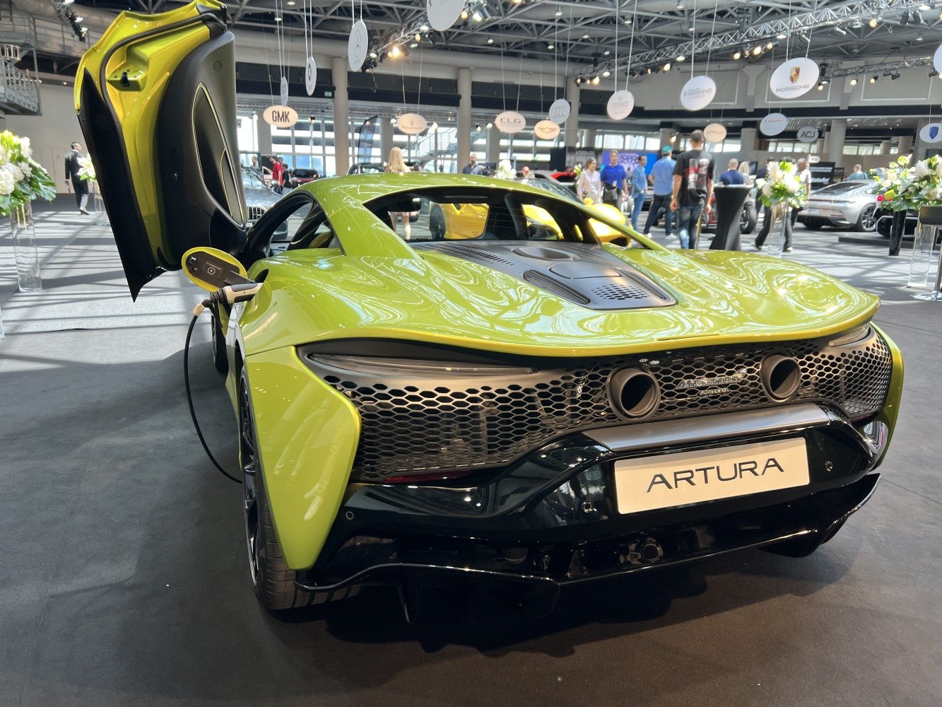 Rear view of hybrid supercar plugged in for electric charging