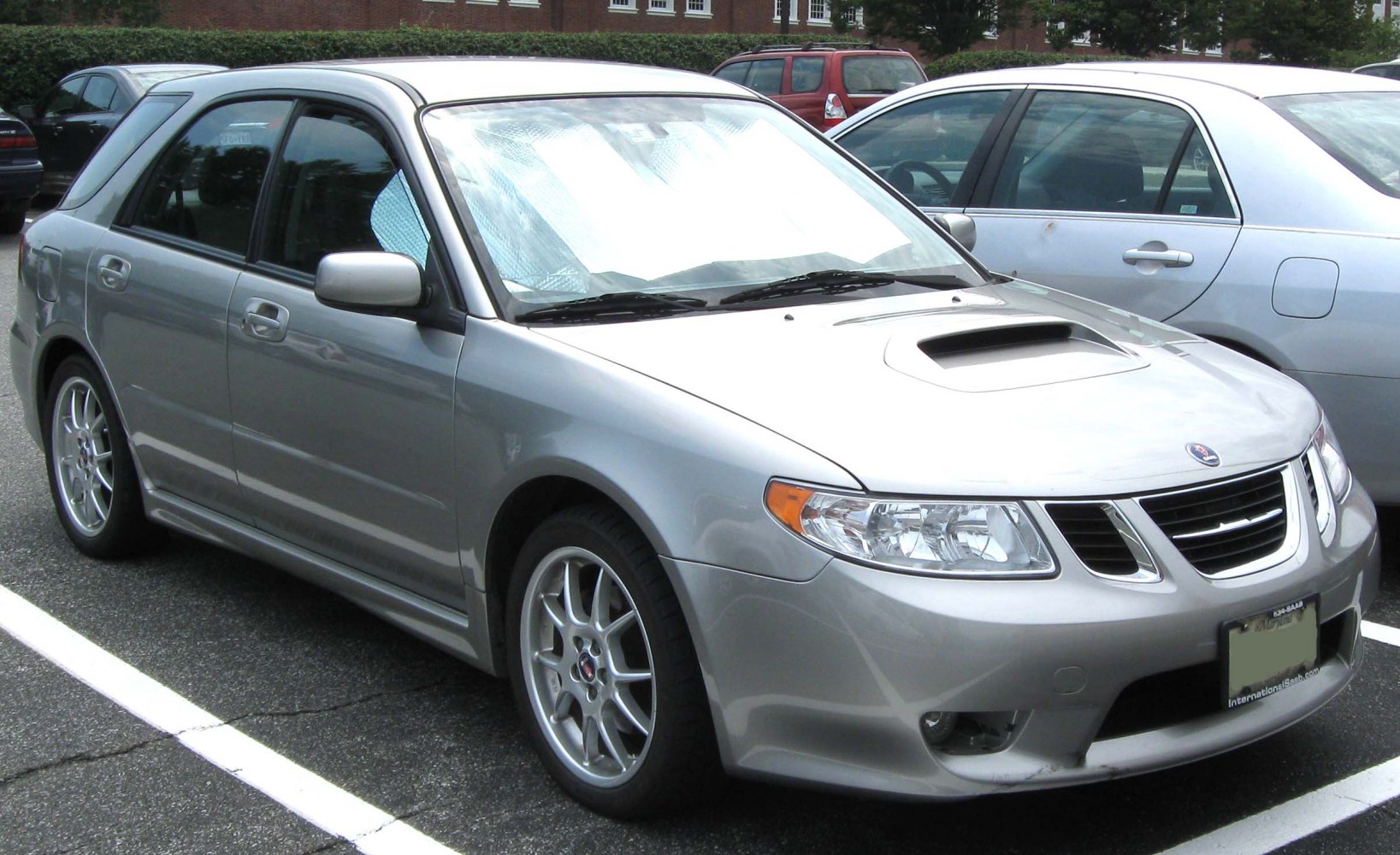 Hood scoop and alloy wheels on a silver compact hatchback